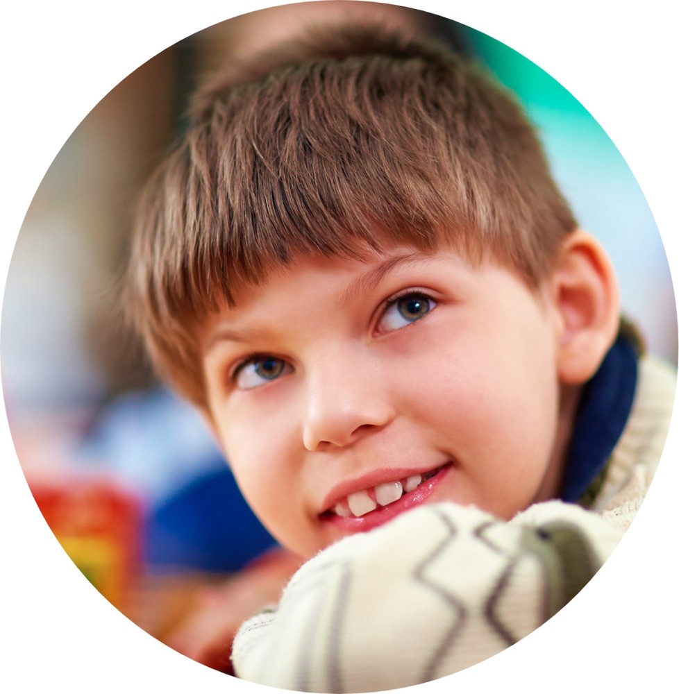 Smiling young boy with short hair and a patterned sweater.